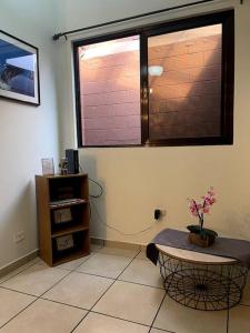 a room with a window and a table with a plant at Casa en Residencial Privado Lomas de San Francisco in San Salvador