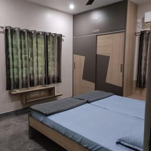 - une chambre avec un lit dans une chambre avec des rideaux dans l'établissement Sukrithi Premium Serviced Apartment - F2, à Chennai