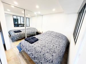 1 dormitorio con cama y espejo en 2 pièces cosy à 15 min de Paris, en Athis-Mons