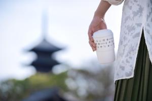 京都的住宿－OMO3 Kyoto Toji by Hoshino Resorts，手上拿着咖啡的女人