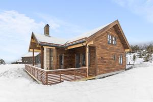 uma cabana de madeira na neve com neve em Nedre-Hydla 38 Premium em Stryn