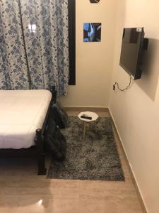 a bedroom with a bed and a tv and a rug at Continental 'LeBe INN in Tirupporūr