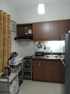 małą kuchnię z drewnianymi szafkami i zlewem w obiekcie Rhapsody Residences Mandolin bldg w mieście Manila