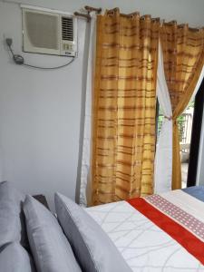 sypialnia z łóżkiem i oknem z klimatyzacją w obiekcie Rhapsody Residences Mandolin bldg w mieście Manila