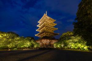 ein großes Gebäude mit einem Turm in der Nacht in der Unterkunft OMO3 Kyoto Toji by Hoshino Resorts in Kyoto