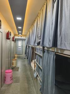- un couloir avec des rideaux bleus dans un casier dans l'établissement Rest Inn Hostel Dormitory, à Mumbai