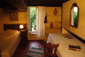 a bedroom with two beds and a window at Hôtel particulier Maleteste in Dijon
