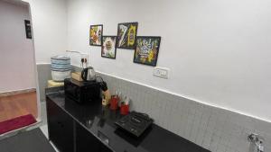 a kitchen with a black counter with pictures on the wall at Villa Verona in Mumbai