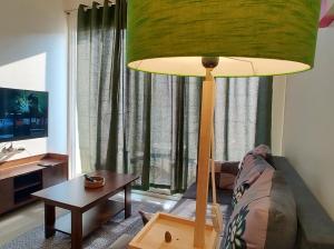 a living room with a lamp and a couch and a table at No Fixed Address in Marmagao