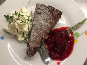 un plato blanco con un trozo de comida y un tenedor y salsa en Bioweingut Hauerhof 99 -apartment 2, en Klosterneuburg
