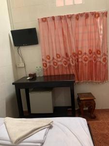 uma secretária preta num quarto com uma cama em Ditar Guest House D em Battambang