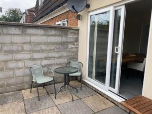 a patio with two chairs and a table next to a window at Brislington villa in Bristol