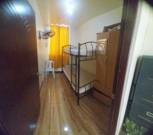 a small room with a bunk bed and a wooden floor at ASF Soriano Place in Mactan