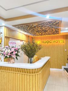 a hotel lobby with a reception counter with flowers at Cat Ba My Ngoc View Hotel in Cat Ba