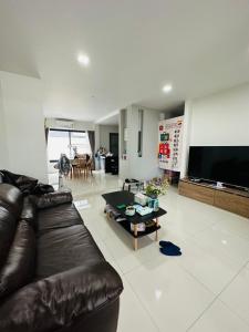 a living room with a leather couch and a coffee table at Malada in Chiang Mai