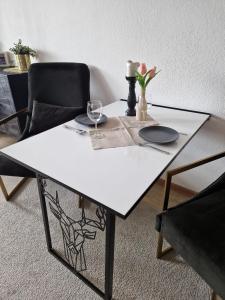 メーデバッハにあるSonnenhang Apartmentの白いテーブルと椅子2脚、花瓶