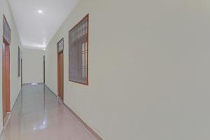 un pasillo con paredes blancas y una ventana en la pared en OYO Flagship Kk Guest House, en Hasanganj