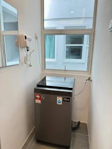 a small refrigerator in a room with a window at Hillview Cube w/Rooftop Pool in Kuah