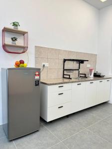 a kitchen with a refrigerator and fruit on the counter at Hillview Cube w/Rooftop Pool in Kuah