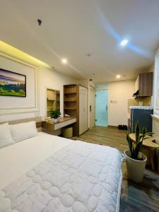 a bedroom with a large white bed and a kitchen at Khách sạn căn hộ Sentosa Coco in Hà Quảng (4)