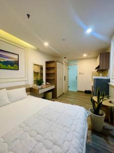 a bedroom with a large white bed and a kitchen at Khách sạn căn hộ Sentosa coco - Phương Nam in Hà Quảng (4)