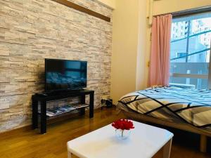 a living room with a bed and a tv at Diamante Yakuin - Vacation STAY 71963v in Fukuoka