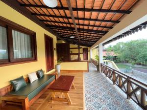 porche con banco y mesa en el balcón en Villa Romduol, en Kampot