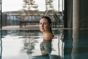 una mujer está sentada en una piscina en Loxone Campus, en Kollerschlag