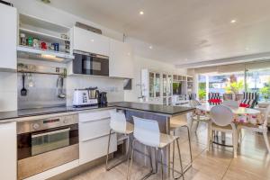 a kitchen with white cabinets and a table and chairs at Les Palmiers in Palavas-les-Flots