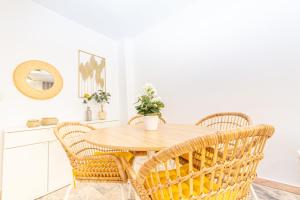 une salle à manger avec une table en bois et des chaises en osier dans l'établissement Paseo Maritimo Puerto Deportivo Yate IV, à Fuengirola