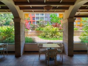 a patio with a table and chairs and a balcony at No Fixed Address in Marmagao