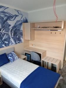 a bedroom with a bed and a desk and a bed and a desk at Hotel Merlot in Eger
