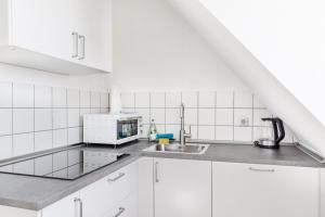 a white kitchen with a sink and a microwave at Zentrales charmantes Apartment in Kulmbach