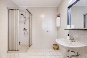 een witte badkamer met een douche en een wastafel bij Zentrales charmantes Apartment in Kulmbach