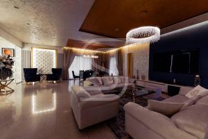 a large living room with couches and a chandelier at Milenium by Kristal Collection in Bucharest