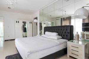 a white bedroom with a large bed and a mirror at SunnyRent. Luxury TJ White Villa & Room in Ungasan