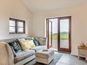a living room with a couch and an open door at Huntington - 4 berth renovated barn in Combe Martin