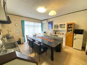 una cucina e una sala da pranzo con tavolo e sedie di ゲストハウス山吹 a Toyama