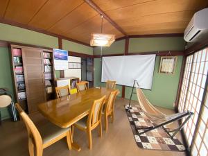 ゲストハウス山吹 في توياما: غرفة طعام مع طاولة وكراسي خشبية