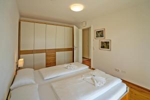 two beds in a bedroom with white walls at Fewo Marca in Oy-Mittelberg