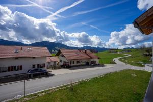 a street with houses and a car on a road at Fewo Marca in Oy-Mittelberg