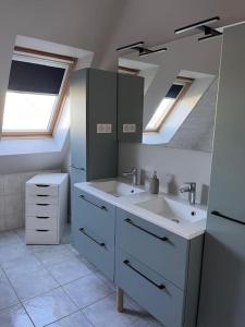 ein Bad mit einem Waschbecken und einem Spiegel in der Unterkunft La maison de la cavalière in Seltz