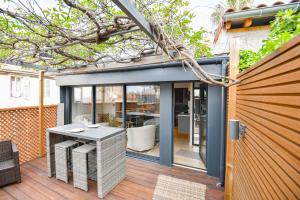 une terrasse en bois avec une table. dans l'établissement La Terrasse Ricard - Belle maison 1 ch avec clim, à Marseille