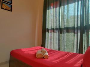 two towels sitting on a bed in front of a window at No Fixed Address in Marmagao