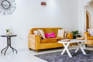 ein Wohnzimmer mit einem Sofa und einem Tisch in der Unterkunft Karibu Diani in Diani Beach