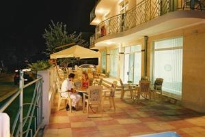 Ein Mann sitzt an einem Tisch auf einer Terrasse in der Unterkunft Hotel Diva in Rawda