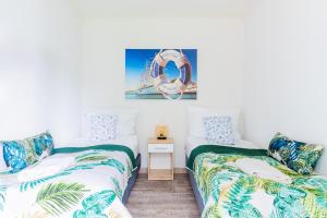 2 camas en una habitación con una noria en la pared en "AGUŚ" Komfortowe i nowczesne domki w cichej okolicy niedaleko plaży, en Ostrowo