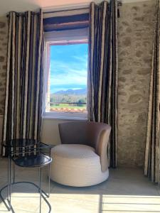 a living room with a chair and a window at Auberge Du Roua in Argel&egrave;s-sur-Mer