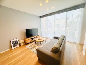 a living room with a couch and a flat screen tv at Akikawa Koshi 2 プレミアム鉄骨 一棟貸切ヴィラ in Yuge