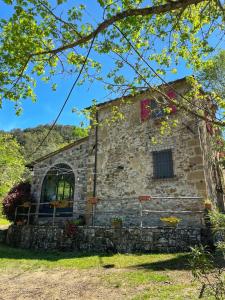 an old stone building with a window at Casa nel bosco Il Grottone in Montaione
